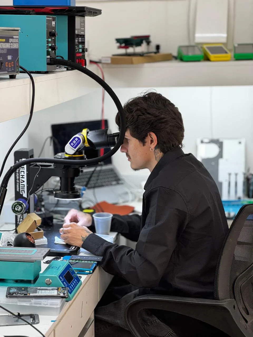 Técnico da 67 Celulares realizando um reparo especializado